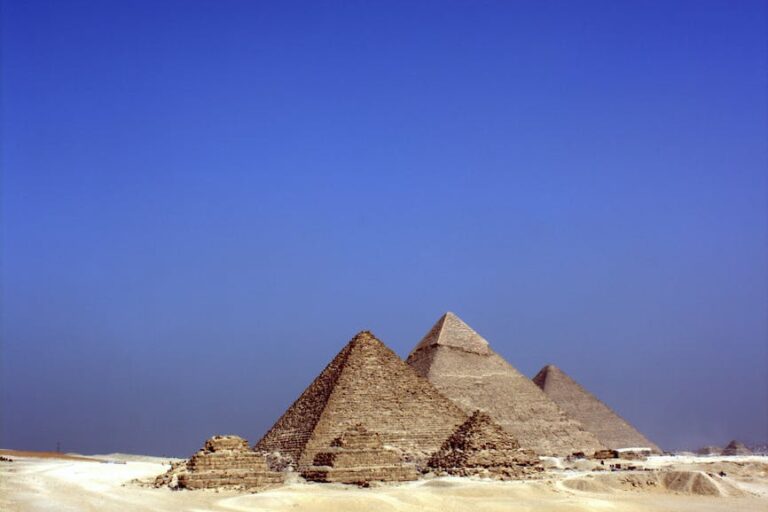 grey concrete pyramids on the middle of the dessert during daytime